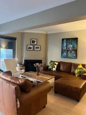 a living room with leather furniture and a fireplace at La Gratitude 8 luxury in Stellenbosch CENTRAL in Stellenbosch