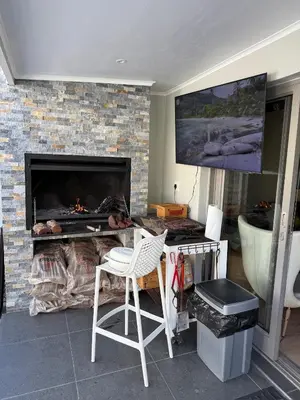 a living room with a fireplace and a chair and a television at La Gratitude 8 luxury in Stellenbosch CENTRAL in Stellenbosch