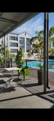 a green bench sitting in front of a building at The Sandown Blouberg self catering unit in Parklands