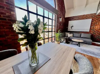 a vase of flowers on a table in a living room at Ben's Apartment in Stellenbosch