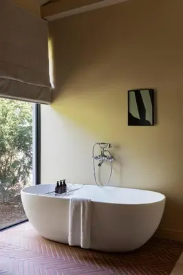 a white bath tub in a bathroom with a window at Boschendal Farm Estate in Franschhoek