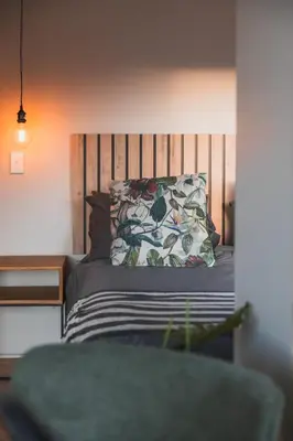 a bed with a wooden headboard and a pillow at Springsteen Cabins in Rawsonville