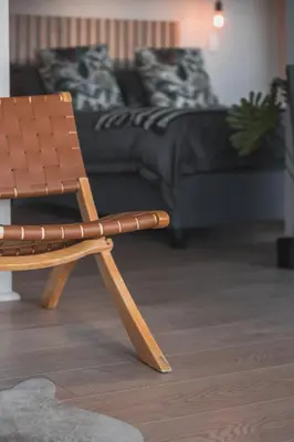 a wooden chair in a living room with a couch at Springsteen Cabins in Rawsonville