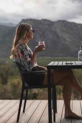 a woman sitting in a chair drinking a drink at Springsteen Cabins in Rawsonville