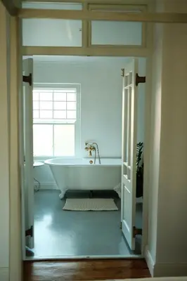 a white bath tub in a bathroom with a window at Gabriëlskloof Farm House in Botrivier