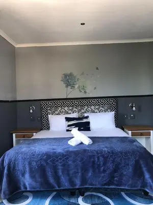 a bed with a teddy bear sitting on top of it at Bergsig Casa Guest House in Cape Town