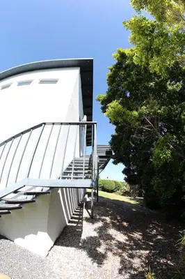 a white staircase with a metal railing next to a tree at 116m² SeaView TopLuxury Apart, Bay & Mountain View in Somerset West
