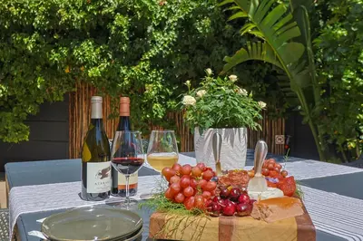 a table with two bottles of wine and grapes at Saffron House in Hermanus