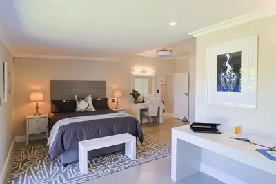 a bedroom with a bed and a desk in it at Saffron House in Hermanus