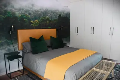 a bedroom with a bed with a painting on the wall at Designer Luxe Stellies Studio in Stellenbosch