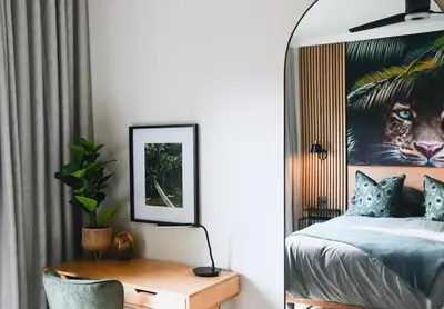 a bedroom with a bed and a picture of a tiger at Designer Luxe Stellies Studio in Stellenbosch