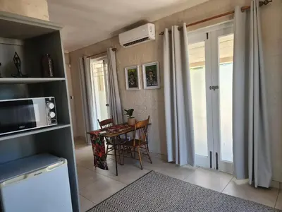 a kitchen with a table with chairs and a microwave at Stirling House in Paarl