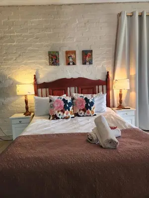 a bed with two lamps and two pillows on it at Stirling House in Paarl