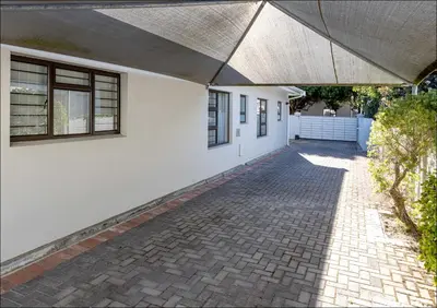 a white house with a brick driveway at Seabreeze in Hermanus