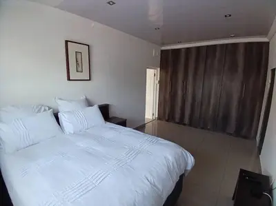 a bedroom with a large white bed in a room at One bedroom apartment. in Cape Town