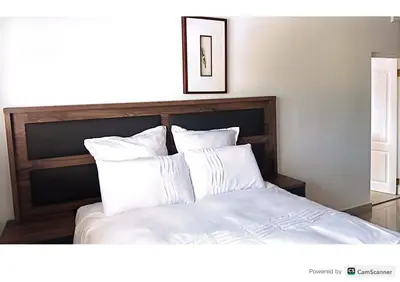 a bedroom with a bed with white sheets and pillows at One bedroom apartment. in Cape Town
