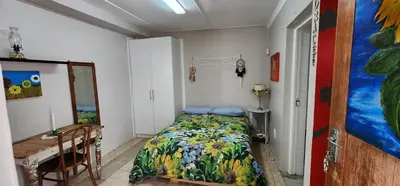a bedroom with a bed and a table in it at Sundance in Central Greyton in Greyton