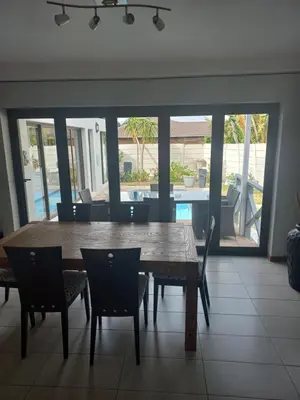 a dining room with a wooden table and chairs at Crystal Villa Guesthouse in Cape Town