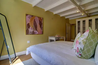 a bedroom with a bed and a painting on the wall at Dieu Donne in Hermanus