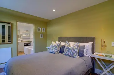 a bedroom with a bed and a bathroom at Dieu Donne in Hermanus