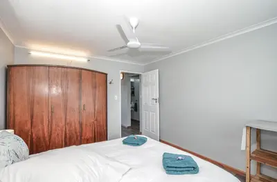 a bedroom with a bed with two towels on it at The Neighbours - Kleinmond in Kleinmond
