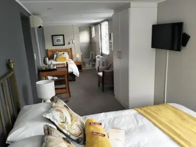 a bedroom with a bed and a living room at Hermanus 13 on 2nd Guest Rooms in Hermanus