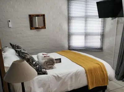 a bedroom with a bed with a stuffed animal on it at Hermanus 13 on 2nd Guest Rooms in Hermanus