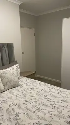 a bedroom with a large bed with a pillow on it at Modest Home in Cape Town in Cape Town