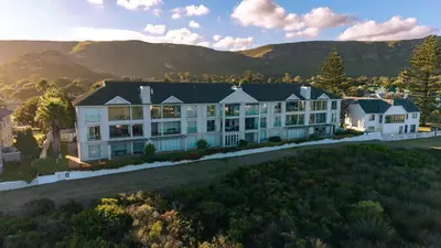 an aerial view of a large white building with mountains in the background at Seaside Serenity: Tranquil Oceanview Retreat in Hermanus