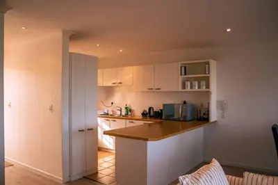 a kitchen with white cabinets and a counter top at Seaside Serenity: Tranquil Oceanview Retreat in Hermanus