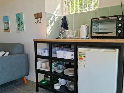 a kitchen with a counter with a microwave and a tv at 'BoStrand' - Private and Central, only 2 min walk to beach - sleeps 2 in Gordonʼs Bay