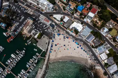 an aerial view of a beach with people on it at Cardamom Cottage, sleeps 3 and 1 min walk to beach in Cape Town