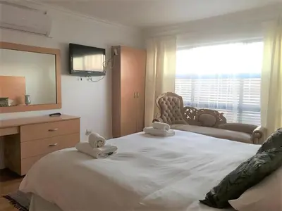 a bedroom with a large bed with towels on it at The Other House - Cape Town in Cape Town
