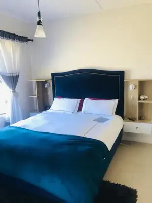 a bedroom with a large bed with a blue headboard at Luxurious Lifestyle in Cape Town