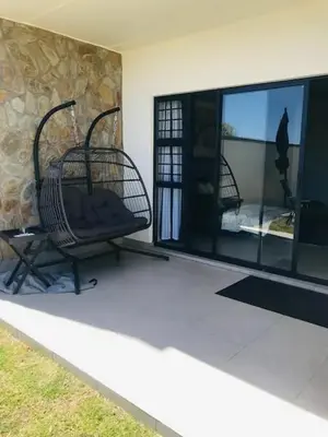 a porch with two chairs and a large window at Luxurious Lifestyle in Cape Town