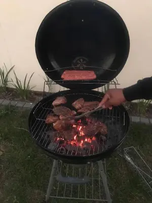 a person is cooking food on a grill at Luxurious Lifestyle in Cape Town