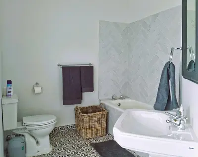 a bathroom with a tub and a toilet and a sink at '79 Protea' Charming self-catering Home, sleeps 6 with Sea Views in Gordonʼs Bay
