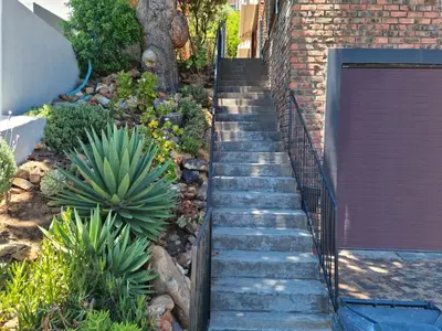 a set of stairs leading up to a brick building at '79 Protea' Charming self-catering Home, sleeps 6 with Sea Views in Gordonʼs Bay