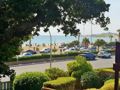 a parking lot with cars parked on the beach at 'Terrace-On-Sea'- 2 Min from the beach, 2 bedroom town house, Sleeps 4 in Cape Town