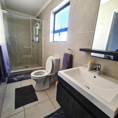 a bathroom with a sink and a toilet and a shower at 1d - Serene Retreat of Parklands in Cape Town