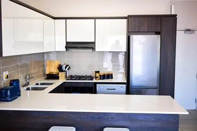 a kitchen with a white counter and a refrigerator at 1d - Serene Retreat of Parklands in Cape Town