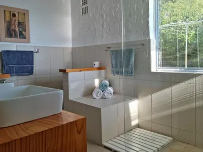 a bathroom with a sink and a tub and a window at '75 Protea' 4 Bedroom Holiday Home for 8 with Private Pool and Ocean Views in Cape Town