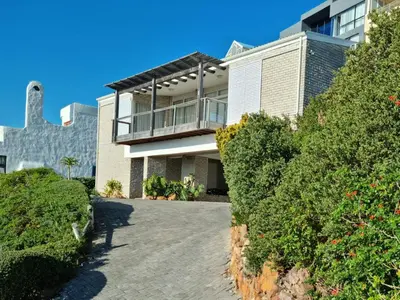 a large house with a balcony and bushes at '75 Protea' 4 Bedroom Holiday Home for 8 with Private Pool and Ocean Views in Cape Town