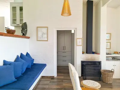 a living room with a blue couch and a fireplace at '75 Protea' 4 Bedroom Holiday Home for 8 with Private Pool and Ocean Views in Cape Town