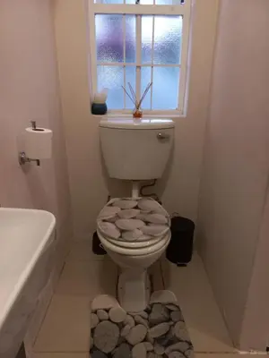 a bathroom with a toilet with a window at Freys 1 in Cape Town
