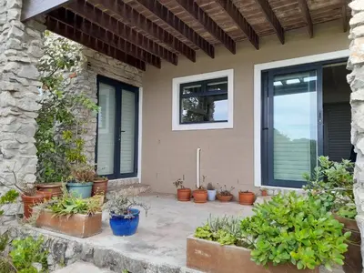 a group of potted plants sitting outside of a house at Peaceful Seaside Cottage, Betty's Bay Accommodation in Clareport
