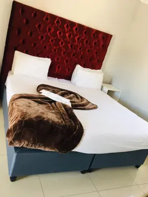 a bedroom with a bed with a blanket on it at Victoria Lodge Studio Apartment in Cape Town
