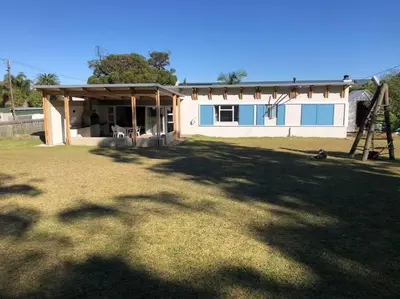 a house with a large yard in front of it at Rustica in Onrus close to the beach in Hermanus