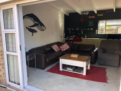 a living room with a couch and a table at Rustica in Onrus close to the beach in Hermanus