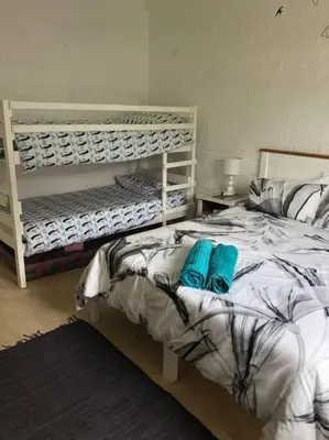 a bedroom with two bunk beds with blue pillows at Rustica in Onrus close to the beach in Hermanus